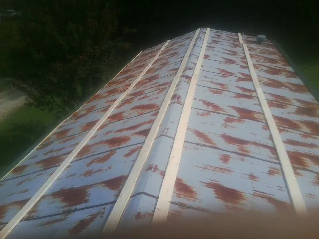 Rusted metal roof panels with new wood purlins before replacement — Storm Damage Roof Repair in Orient by Roofing Brothers